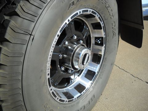1996 Ford F-250 - Aftermarket wheel and tire detail on a truck, BFGoodrich tires and a chrome center cap.