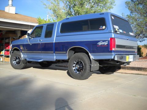 1996 Ford F-250 - This 1996 Ford F-250 pickup truck is shown from the rear three-quarter view, equipped with a camper shell.
