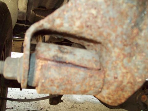 1989 Ford F-150 - This heavily rusted suspension component shows significant wear and tear, indicating potential maintenance needs.