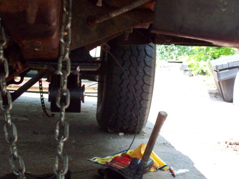 1989 Ford F-150 - Undercarriage view with chains and a tire visible, tools are on the ground.
