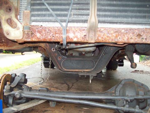 1989 Ford F-150 - Underbody view of rusted truck frame and suspension components, possibly undergoing modification.