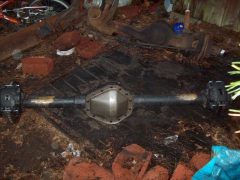 1989 Ford F-150 - A rear axle assembly is shown, possibly for a truck, with a metal cover and disc brakes.