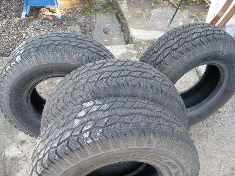 Four tires with visible tread patterns and sidewall text