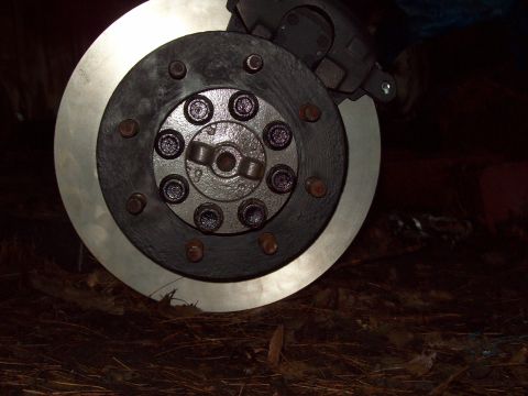 1989 Ford F-150 - A close-up view of a vehicle's brake rotor and caliper, showing the mechanical components.