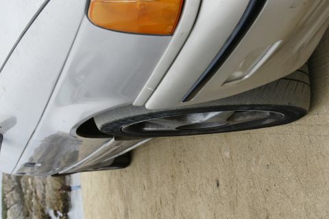 1990 Ford Taurus - The front corner of a silver 1990 Ford Taurus shows its amber turn signal and wheel.