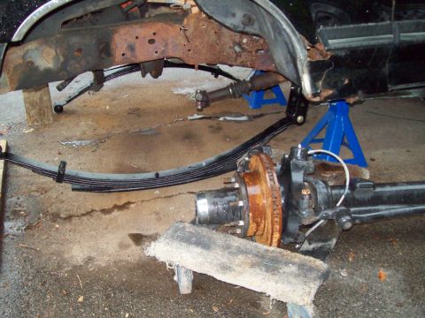 1989 Ford F-150 - The rear axle and suspension components of a truck are shown while undergoing maintenance or modification.