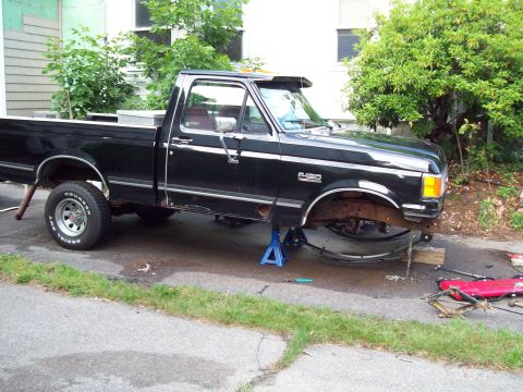 1989 Ford F-150 - This black 1989 Ford F-150 pickup truck is shown on jack stands, indicating it is undergoing maintenance or repair.