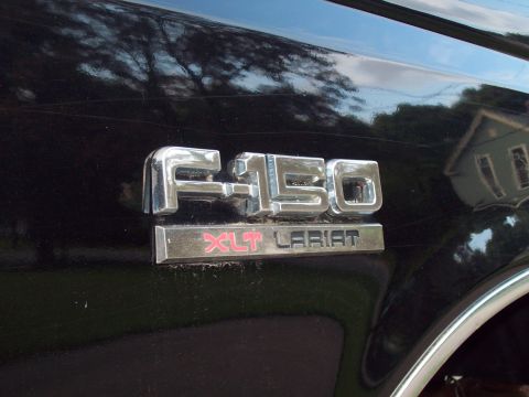 1989 Ford F-150 - Close-up of the F-150 XLT Lariat emblem on a black truck.