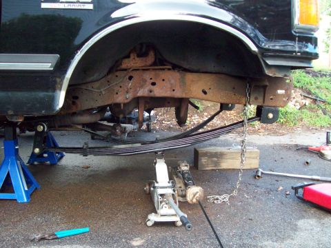 1989 Ford F-150 - The frame and suspension of a 1989 Ford F-150 are visible while supported by jack stands and a floor jack.
