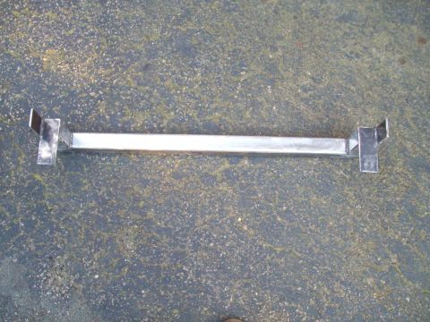 1989 Ford F-150 - A metal bar with angled brackets is shown against a dark, textured ground. The part appears to be custom-made.