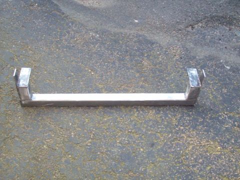 1989 Ford F-150 - A custom metal bracket, likely for automotive use, is shown resting on asphalt.