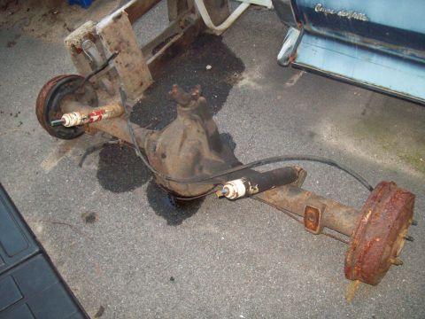 1989 Ford F-150 - A detached rear axle assembly sits on asphalt, showing signs of rust and wear.