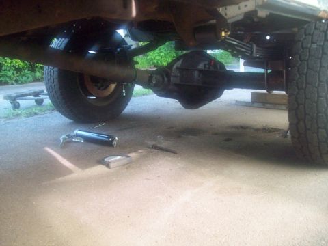 1989 Ford F-150 - Close-up of rear axle and suspension components with tools nearby on concrete.