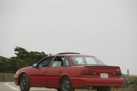 1990 Ford Taurus - Rear view of a red 1990 Ford Taurus sedan with a California license plate.