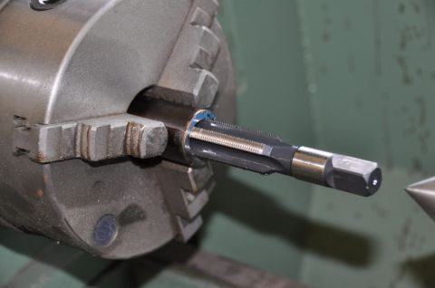 1996 Ford Bronco - A tap is centered in a lathe chuck, ready for machining.