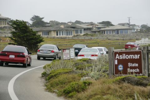 1990 Ford Taurus - A red 1990 Ford Taurus drives on a coastal road near Asilomar State Beach.