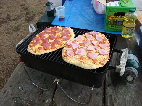 1989 Ford Bronco - Grilling two pizzas outdoors with a propane grill and various supplies.