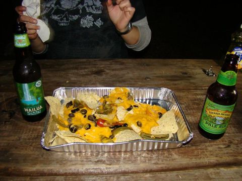 1989 Ford Bronco - A foil tray of nachos sits on a wooden picnic table with two bottles of beer.