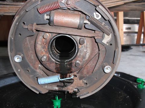 1991 Ford Bronco - Close-up of a vehicle brake drum assembly, showing brake shoes, springs, and a wheel cylinder.