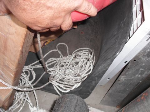 1991 Ford Bronco - A close-up view of a coiled rope and a wooden beam, with a tire in the foreground.