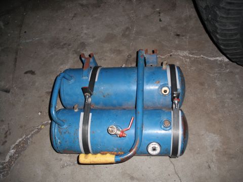 1991 Ford Bronco - This photo shows a pair of blue air tanks, possibly for a vehicle's air brake system, resting on a concrete floor.