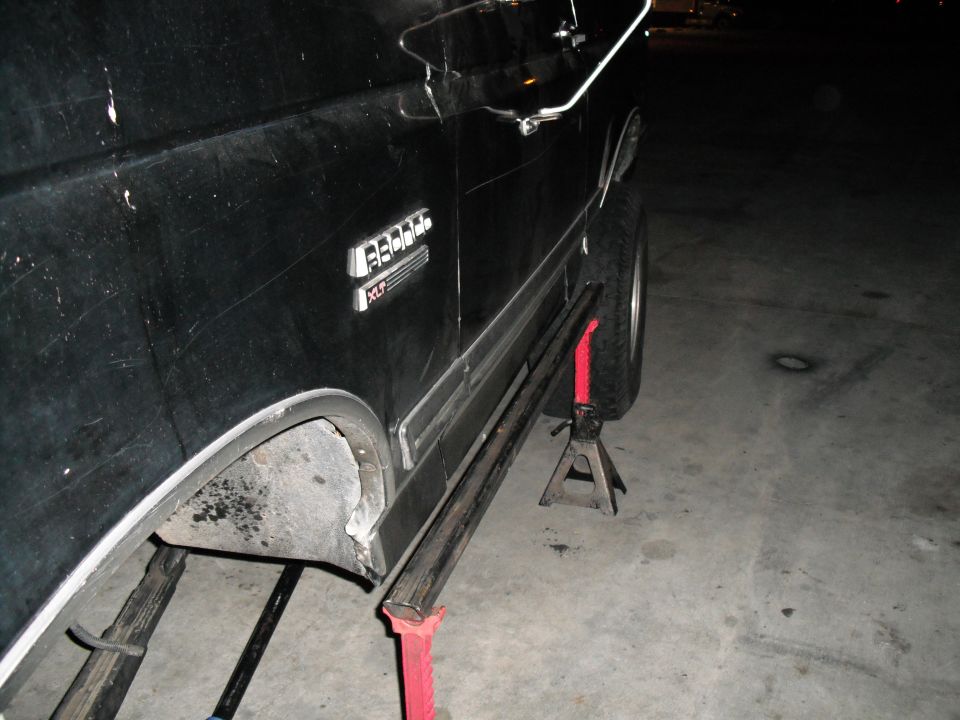 Black 1991 Ford Bronco XLT side view, lifted on jack stands
