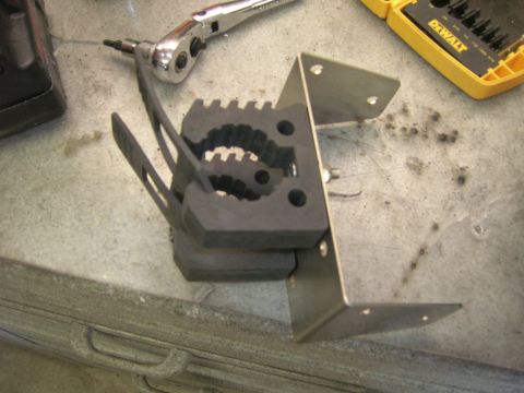 1996 Ford Bronco - A close-up view of a clamp mount assembly, with tools nearby on a workbench.