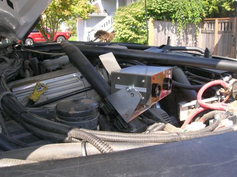 1996 Ford Bronco - Aftermarket welder installed in the engine bay of a vehicle, with a red truck visible in the background.