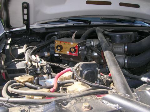 1996 Ford Bronco - Aftermarket welder installed in the engine bay of a vehicle.