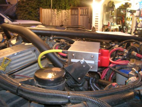 1996 Ford Bronco - Aftermarket electrical components installed in an engine bay, including a silver box with red connectors and heavy gauge wiring.
