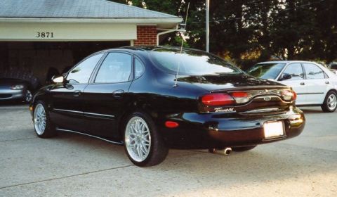 1999 Ford Taurus - Rear view of a black 1999 Ford Taurus with aftermarket wheels.