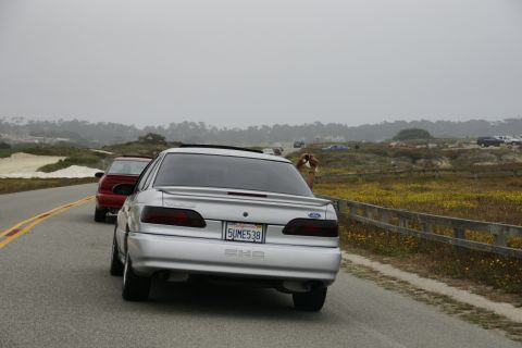 1990 Ford Taurus - Silver 1990 Ford Taurus with a red car following on a scenic road.