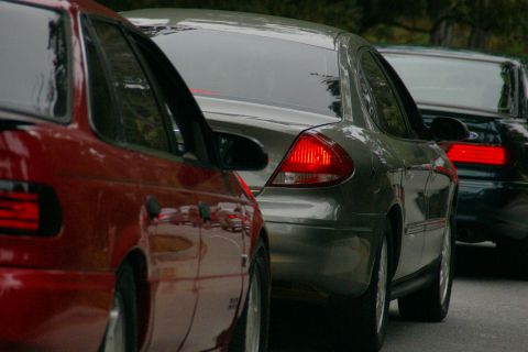 1990 Ford Taurus - Three cars, including two Ford Tauruses, are stopped in traffic.