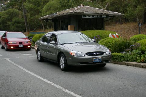 1990 Ford Taurus - Two Ford Tauruses drive past the Pacific Grove Gate entrance.