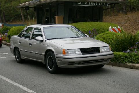 1990 Ford Taurus - This 1990 Ford Taurus sedan is seen in a 3/4 front view, with the Pacific Grove Gate visible in the background.