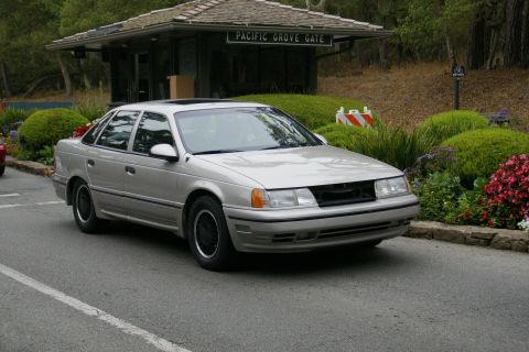 1990 Ford Taurus - A silver 1990 Ford Taurus sedan is parked near the Pacific Grove Gate.
