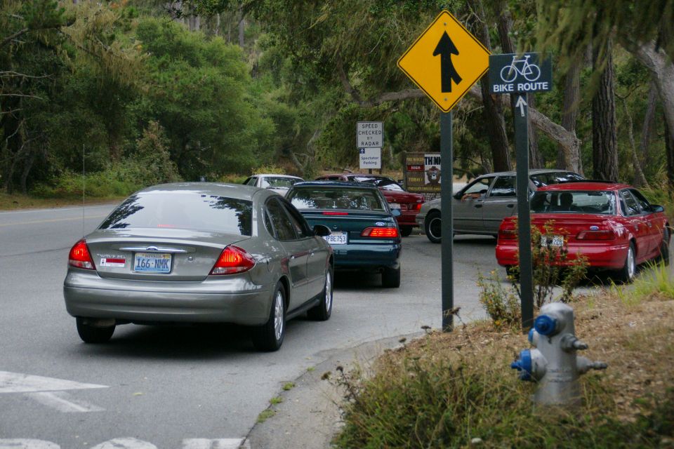 Silver Ford Taurus from behind, license plate 166-NNK. Other cars in traffic behind it