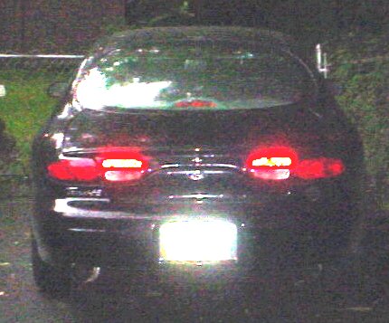 1999 Ford Taurus - Rear view of a dark-colored Ford Taurus sedan, showing its distinctive taillight design.
