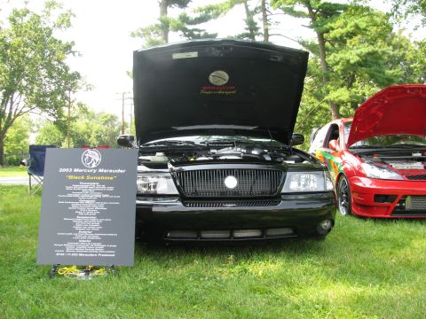 2003 Mercury Marauder - A black 2003 Mercury Marauder is displayed with its hood open, alongside another vehicle at an outdoor car show.