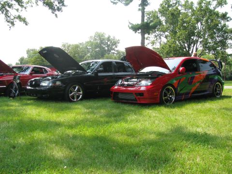2003 Mercury Marauder - Two cars with hoods open are parked on a grassy lawn under trees, with a third car visible to the left.
