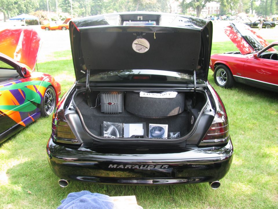 Mercury Marauder open trunk showing audio amplifier and subwoofer install at car show