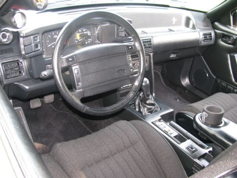2003 Mercury Marauder - The interior of a car features a manual transmission shifter, aftermarket gauges, and a Ford-branded steering wheel.