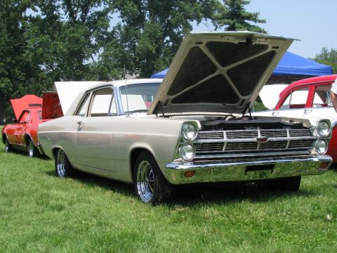 2003 Mercury Marauder - A classic 1966 Ford Fairlane is displayed with its hood up at an outdoor car show.
