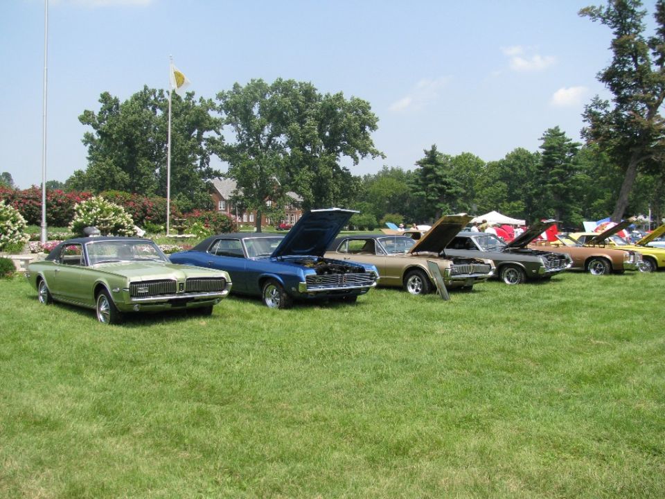Green 1968 Mercury Cougar XR7 parked on grass with other classic cars