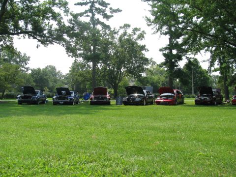 2003 Mercury Marauder - A lineup of cars with their hoods open, displayed on a lawn during an outdoor car show.