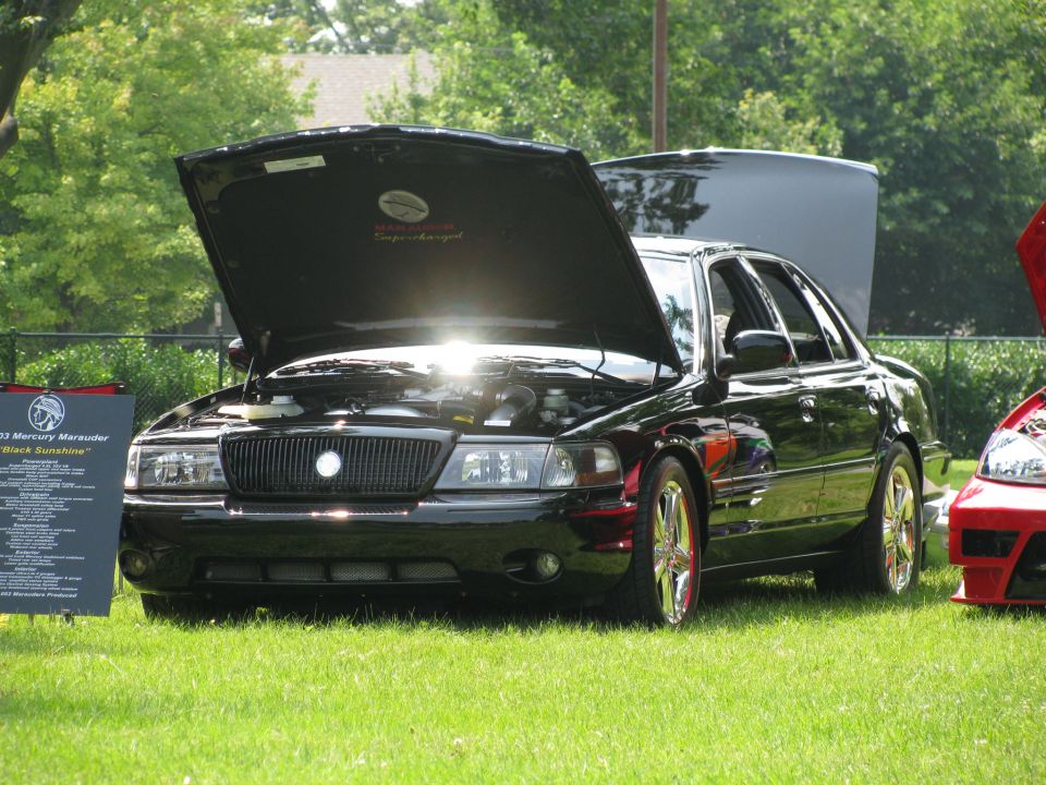 2003 Mercury Marauder with hood open, parked on grass next to another car