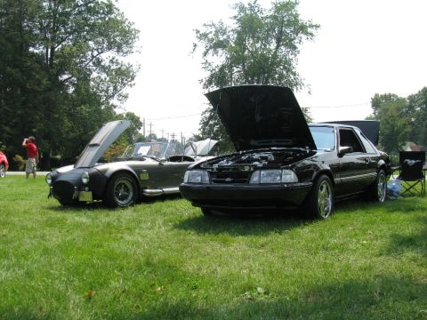 2003 Mercury Marauder - Two cars are parked on a lawn with their hoods open.