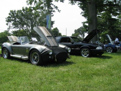 2003 Mercury Marauder - A silver AC Cobra replica is displayed with its hood open at an outdoor car show, alongside other vehicles.