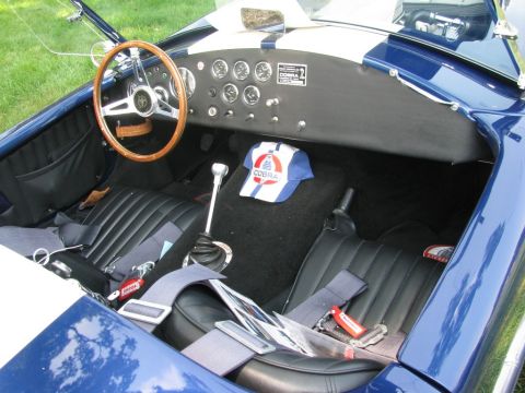 2003 Mercury Marauder - The interior of a blue sports car shows racing seats, a wooden steering wheel, and a dashboard with multiple gauges.