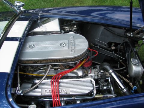 2003 Mercury Marauder - The engine bay of a blue car with white stripes is visible, a Cobra engine and various components.